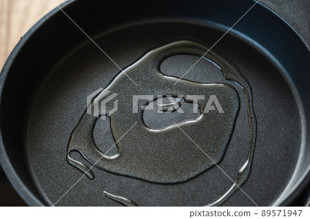 Pour oil into a frying pan Pour oil into a frying pan 89571947