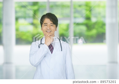 一位身著實驗室外套的中年男醫生在醫院大廳裡 一位身著實驗室外套的中年男醫生在醫院大廳裡 89573201