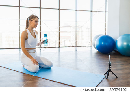 Female fitness trainer doing online workout Female fitness trainer doing online workout 89574102