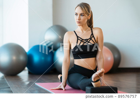 Portrait of serious woman gymnast who sits in twine Portrait of serious woman gymnast who sits in twine 89576757