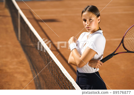Beautiful young woman on the tennis court Beautiful young woman on the tennis court 89576877