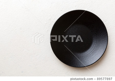 Top view of black plate on cement background. Empty space for your design 89577897