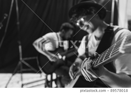Repetition of rock music band at music studio. Cropped image of electric and acoustic guitar players at concert. Rehearsal base Concept of art, music, style 89578018