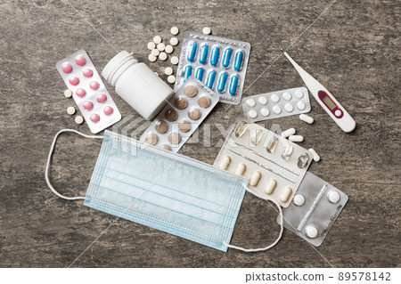 Protective face masks or surgical masks, medicine pills and thermometer on table background. Coronavirus disease. Corona virus concept. Space for text Protective face masks or surgical masks, medicine pills and thermometer on table background. Coronavirus disease. Corona virus concept. Space for text 89578142