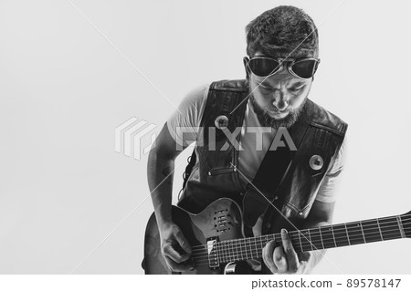 Black and white portrait of stylish man, rock musician with electric guitar isolated on white background. Rehearsal base Concept of art, music, style 89578147