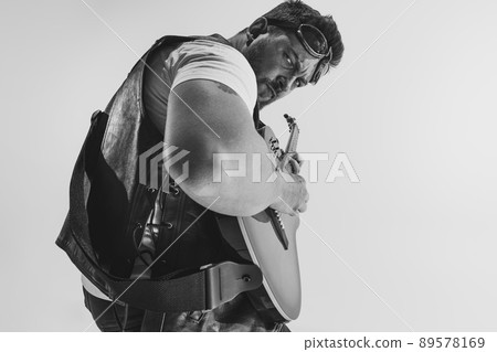 Black and white portrait of stylish man, rock musician with electric guitar isolated on white background. Rehearsal base Concept of art, music, style 89578169