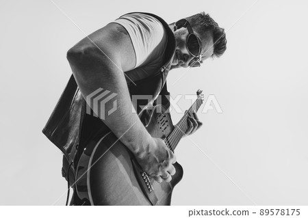 Black and white portrait of stylish man, rock musician with electric guitar isolated on white background. Rehearsal base Concept of art, music, style 89578175