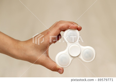White fidget spinner toy in hand of a child 89579771