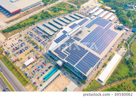 Aerial view of solar panels or solar cells on the roof of shopping mall building rooftop. Power plant, renewable clean energy source. Eco technology for electric power in industry. Aerial view of solar panels or solar cells on the roof of shopping mall building rooftop. Power plant, renewable clean energy source. Eco technology for electric power in industry. 89580062