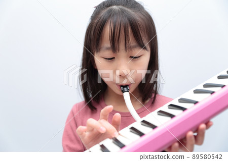 Girl playing keyboard harmonica 89580542