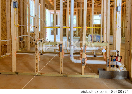 Buildt new home construction featuring hot and cold water PEX plastic plumbing tubes. Buildt new home construction featuring hot and cold water PEX plastic plumbing tubes. 89580575
