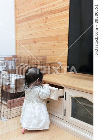 Baby pranking a TV board drawer Baby pranking a TV board drawer 89580651