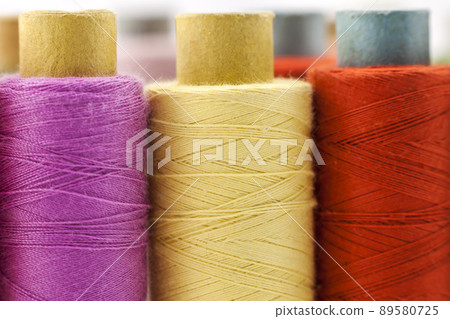 Reels or spools of multicolored sewing threads. Threads of all colors. Shallow depth of field. Close-up macro shot. Reels or spools of multicolored sewing threads. Threads of all colors. Shallow depth of field. Close-up macro shot. 89580725