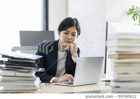 Desk work A young business woman who thinks while looking at the screen of a laptop computer Desk work A young business woman who thinks while looking at the screen of a laptop computer 89580912