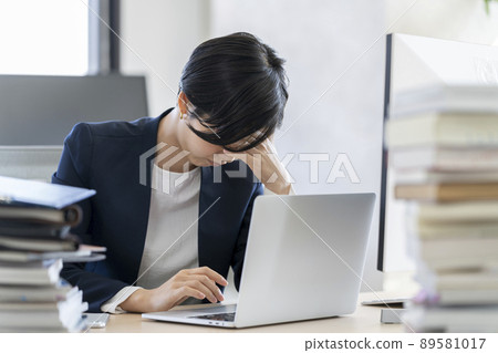 女商人在筆記本電腦前抱著頭工作麻煩/疲勞圖像 89581017