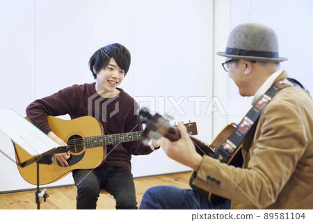 Japanese man playing the guitar 89581104