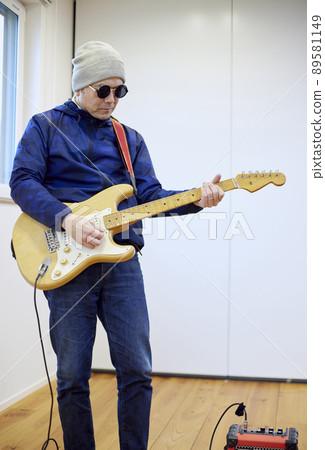 Japanese man playing electric guitar 89581149