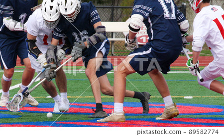 Boys fighting for possession of the ball during a lacrosse game Boys fighting for possession of the ball during a lacrosse game 89582774