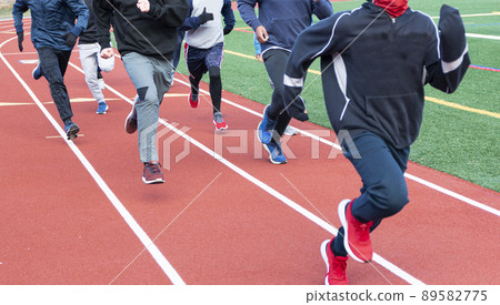 Group of boys running on a track on a cold day Group of boys running on a track on a cold day 89582775