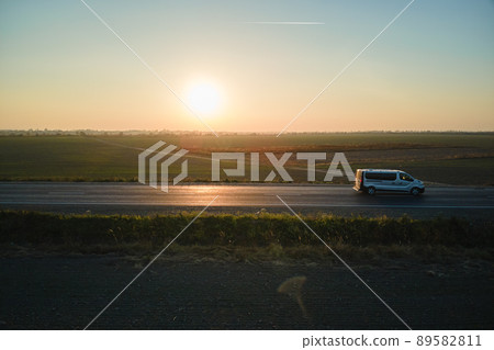 Aerial view of intercity road with blurred fast driving car at sunset. Top view from drone of highway traffic in evening 89582811