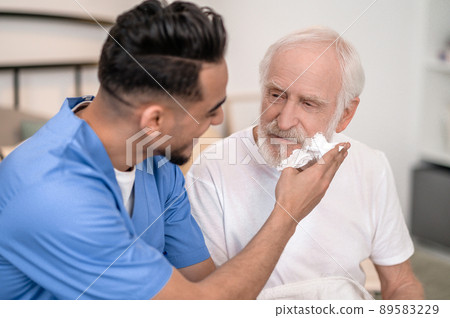 Caretaker getting an elderly man ready for a shave Caretaker getting an elderly man ready for a shave 89583229