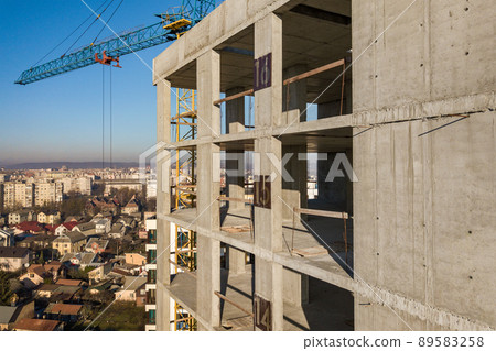 Aerial view of concrete frame of tall apartment building under construction in a city. 89583258