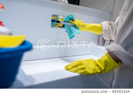 A young housewife cleaning in the bathroom A young housewife cleaning in the bathroom 89583264