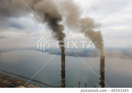 Aerial view of coal power plant high pipes with black smoke moving up polluting atmosphere. 89583265