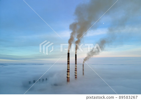Aerial view of coal power plant high pipes with black smoke moving up polluting atmosphere at sunset Aerial view of coal power plant high pipes with black smoke moving up polluting atmosphere at sunset 89583267