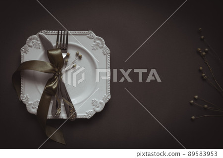 Romantic tabble setting with ribbon, plates, cutlery on black background. Empty plate. Mockup design layout for your text. Love romantic concept. Copy space. Top view. Flat lay. 89583953