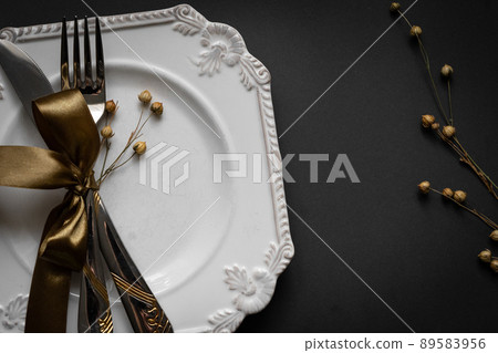 Romantic tabble setting with ribbon, plates, cutlery on black background. Empty plate. Mockup design layout for your text. Love romantic concept. Copy space. Top view. Flat lay. Romantic tabble setting with ribbon, plates, cutlery on black background. Empty plate. Mockup design layout for your text. Love romantic concept. Copy space. Top view. Flat lay. 89583956