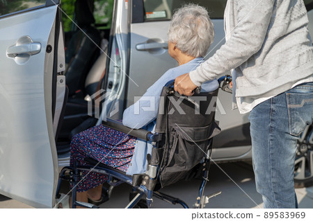 Help and support asian senior or elderly old lady woman patient sitting on wheelchair prepare get to her car, healthy strong medical concept. 89583969