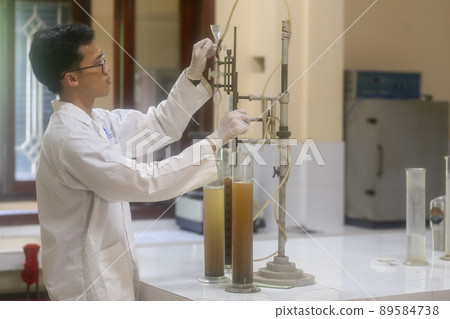 Asian man scientist make sediment experiment with old equipment and measuring cylinder in the laboratory 89584738