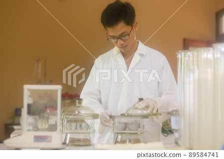 Asian man scientist checking desiccator in the laboratory Asian man scientist checking desiccator in the laboratory 89584741