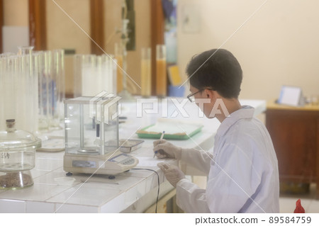 Asian man scientist operating digital laboratory scale in the laboratory 89584759