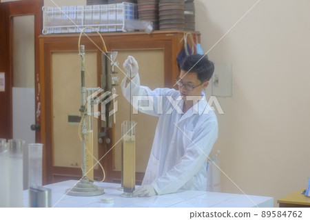 Asian man scientist make sediment experiment with old equipment and measuring cylinder in the laboratory 89584762