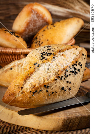 Fresh bread rolls on a rustic wooden table. 89585670