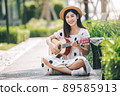 Asian woman playing guitar in the park, lifestyle and recreation concept. 89585913