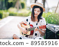 Asian woman playing guitar in the park, lifestyle and recreation concept. 89585916