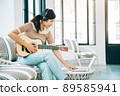 Beautiful Young Asian Woman Playing Guitar and Live Streaming on Social Media at Home While Working from Home in Coronavirus Outbreak Situation , Relax Concept 89585941