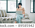 Beautiful Asian People Working on Laptop Computer and Wearing Stereo Headset to Listening Music While Working from Home at Living Room , Remote Work, Live Streaming , Relaxing Concept 89585942
