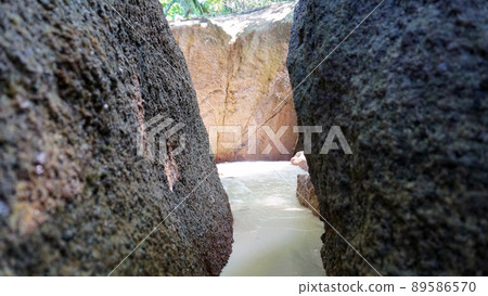 A corridor of stones on the beach. Water flows. A corridor of stones on the beach. Water flows. 89586570