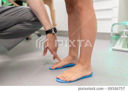 Orthopedic insole. The orthopedist works with the patient. Orthopedic clinic. Choice of insoles in an orthopedic clinic. The orthopedist offers the insole to the patient Foot care Orthopedic insole. The orthopedist works with the patient. Orthopedic clinic. Choice of insoles in an orthopedic clinic. The orthopedist offers the insole to the patient Foot care 89586757