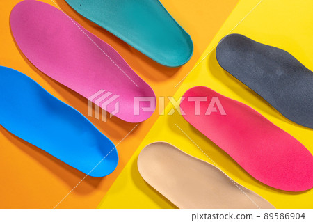 Orthopedic insoles are lined up on a wooden surface. samples of different orthopedic insoles. insoles with a variety of coating. Orthopedic insoles are lined up on a wooden surface. samples of different orthopedic insoles. insoles with a variety of coating. 89586904