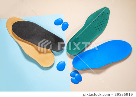 Orthopedic insoles for shoes on a colour background. Foot care Orthopedic insoles for shoes on a colour background. Foot care 89586919