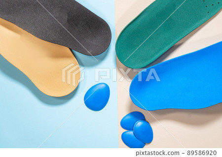 Orthopedic insoles for shoes on a colour background. Foot care Orthopedic insoles for shoes on a colour background. Foot care 89586920