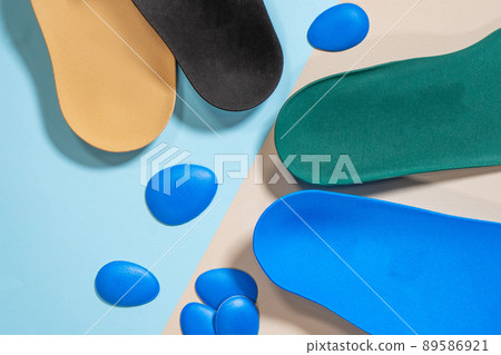 Orthopedic insoles for shoes on a colour background. Foot care Orthopedic insoles for shoes on a colour background. Foot care 89586921