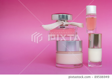 Pink glass perfume bottle, facial cream and nail care product on pink background. Bottle of female perfume, skin care, cosmetic, free space for text. Pink glass perfume bottle, facial cream and nail care product on pink background. Bottle of female perfume, skin care, cosmetic, free space for text. 89586949