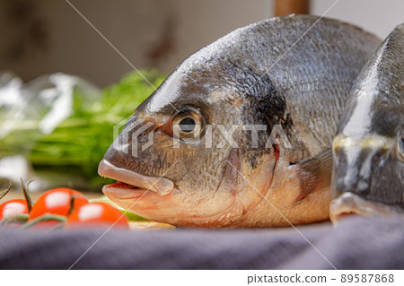 Fresh dorado fish, on a wooden board, two heads close-up 89587868