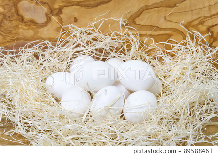 Nest with white eggs. mens hand collect chicken eggs from nest Nest with white eggs. mens hand collect chicken eggs from nest 89588461